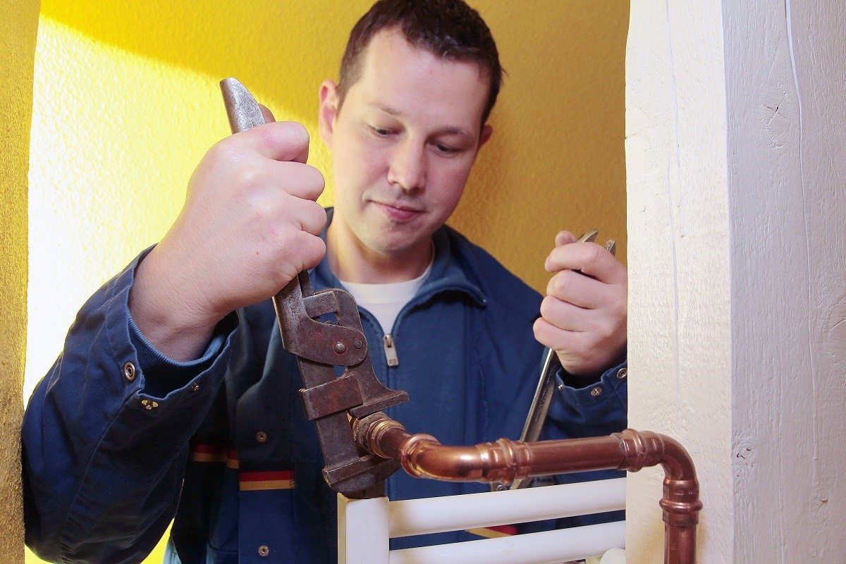 Handwerker-Botschafter Christian Klemm tauscht für den hydraulischen Abgleich ein Ventil aus.