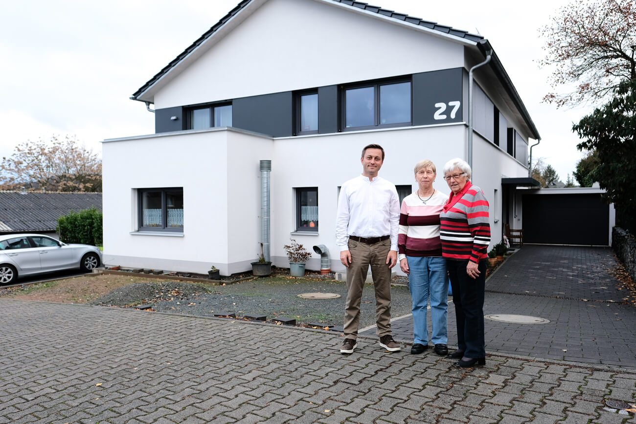 Die drei Mitglieder der Familie Küfner stehen für den Praxistest vor ihrem Passivhaus.