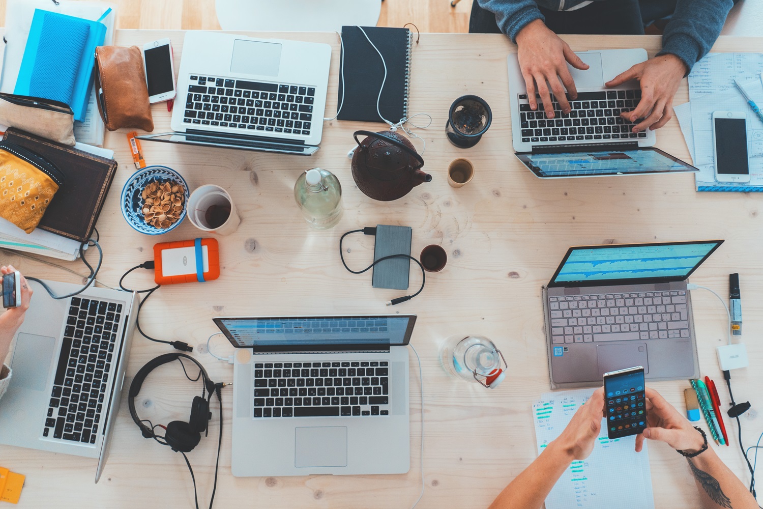 Viele Laptops auf einem Tisch von oben fotografiert.