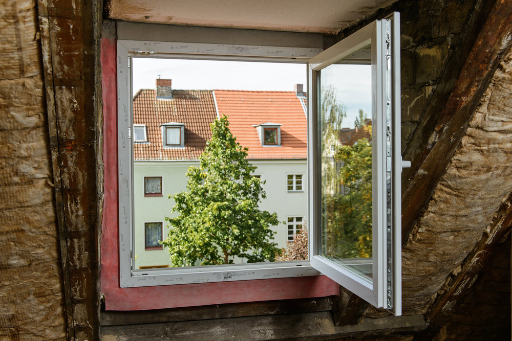 Ein offenes Fenster im Dachgeschoss, die Dachdämmung ist sichtbar. 