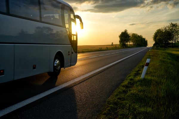 Reisebus auf einer Straße bei Sonnenuntergang