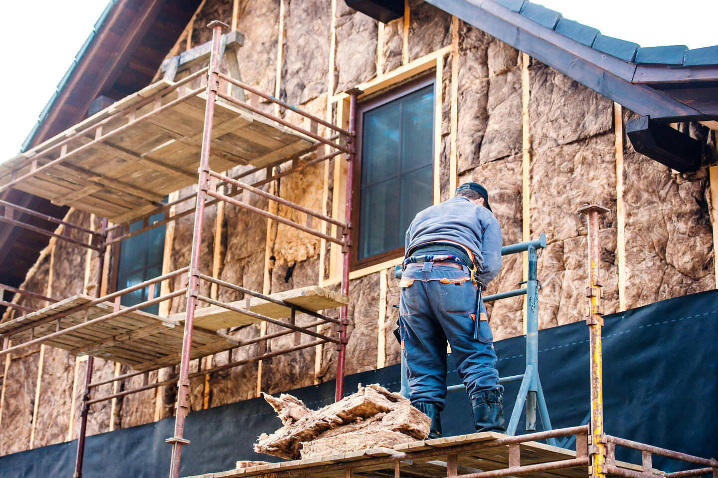 Handwerker dämmen Fassade eines Hauses