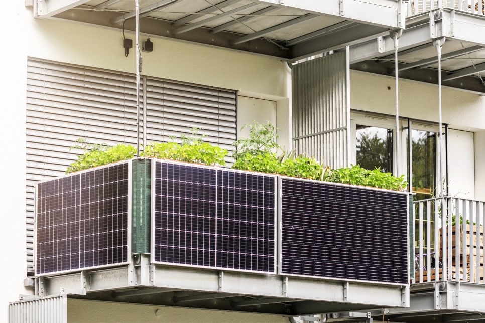 Mehrere Solarpanels hängen an einem Balkongeländer.