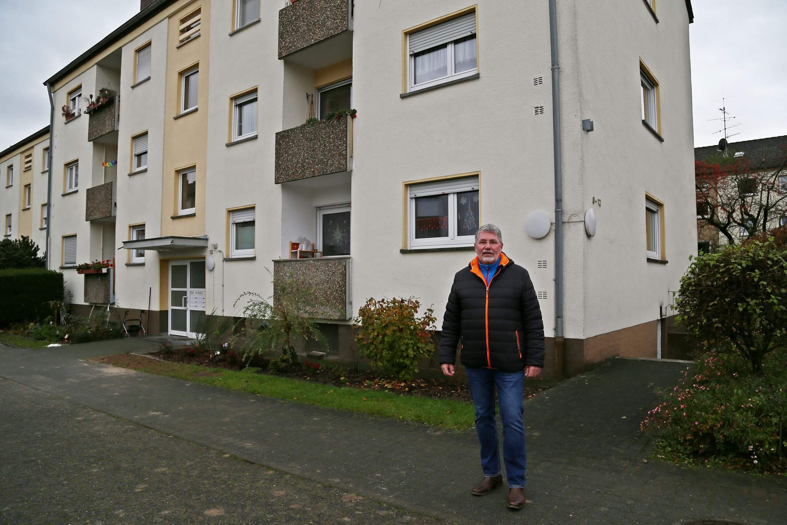 Rolf Schöninger vor Mehrfamilienhaus fern