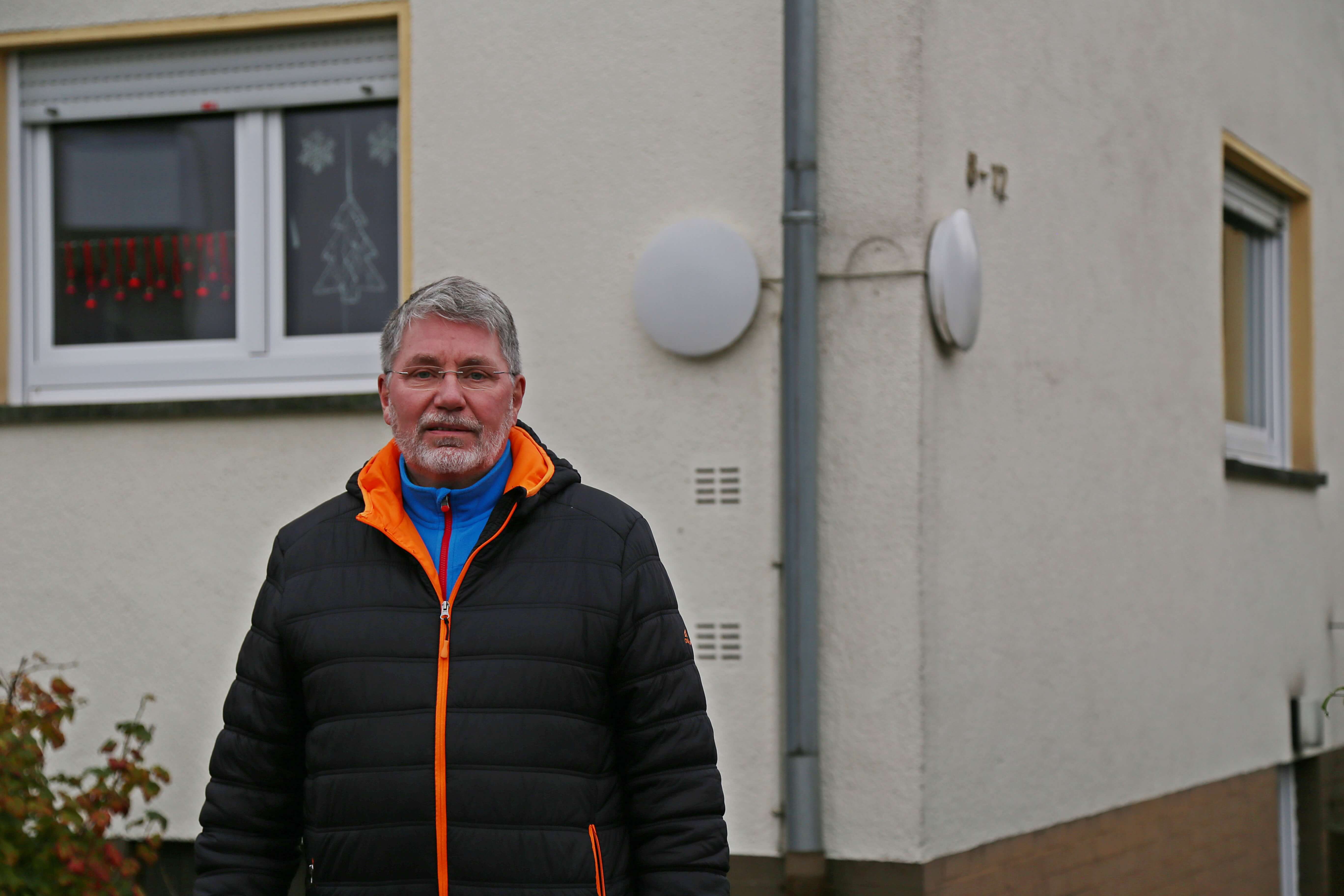 Rolf Schöninger vor Mehrfamilienhaus nah