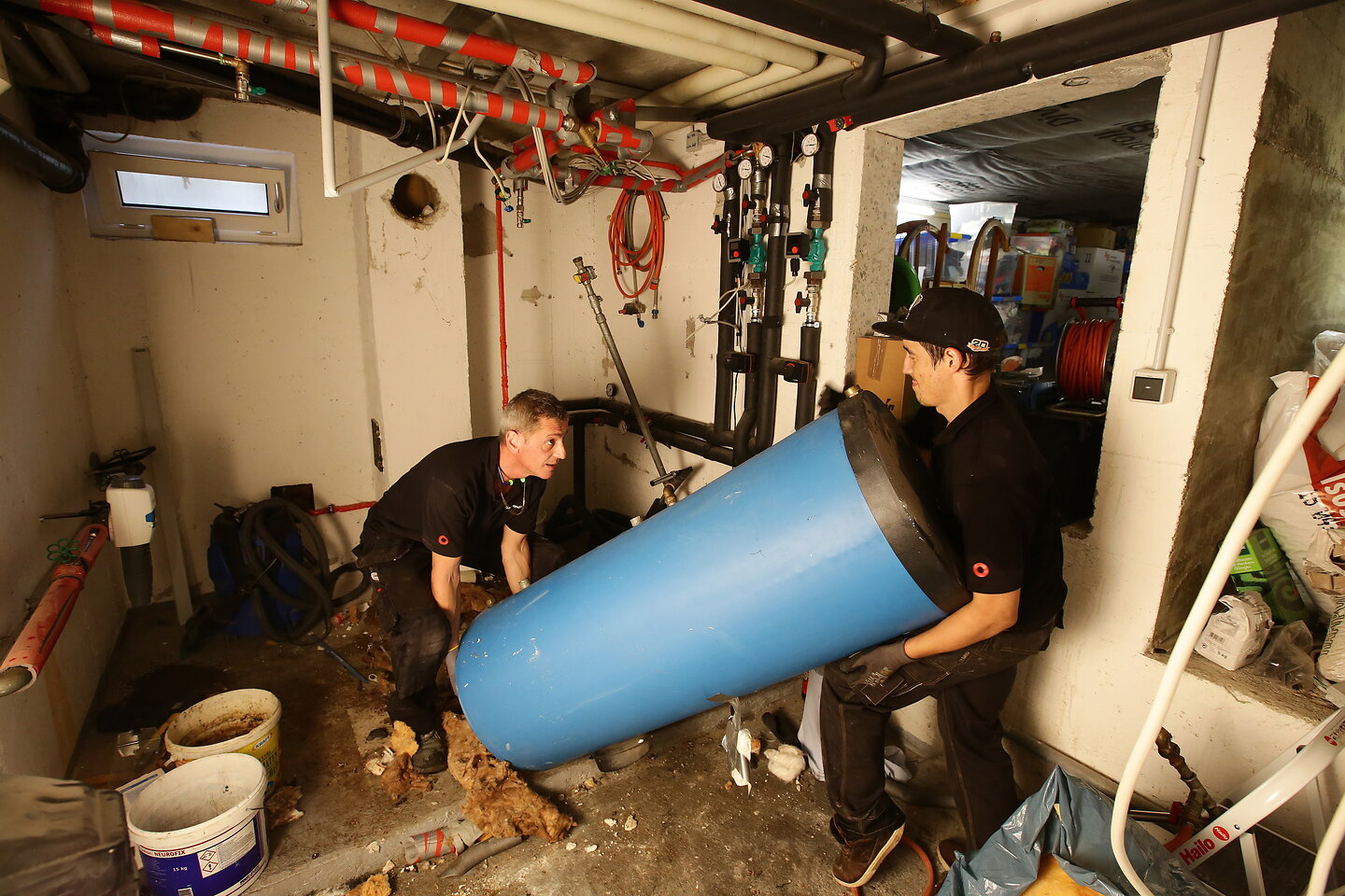 Handwerker tragen den alten Speicher aus dem Keller.