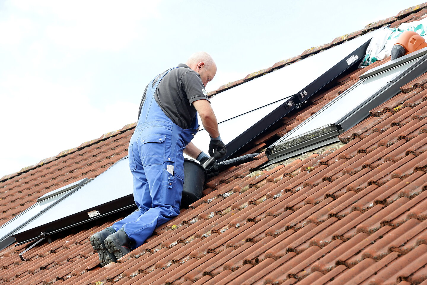 Handwerker schraubt Solarleitung ab.