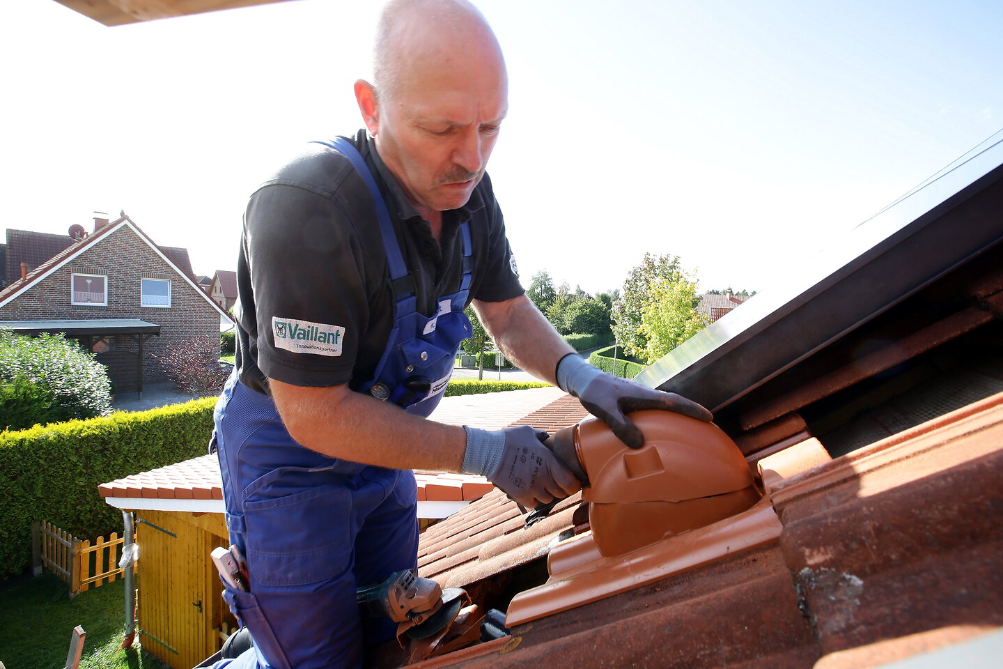 Handwerker verlegt Solar-Dachziegel.