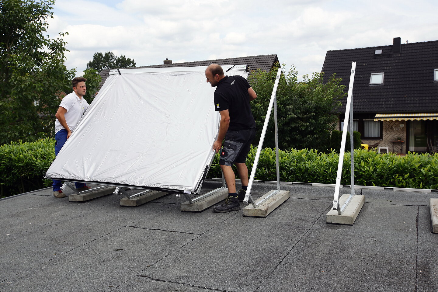 Handwerker stellen Kollektoren auf.