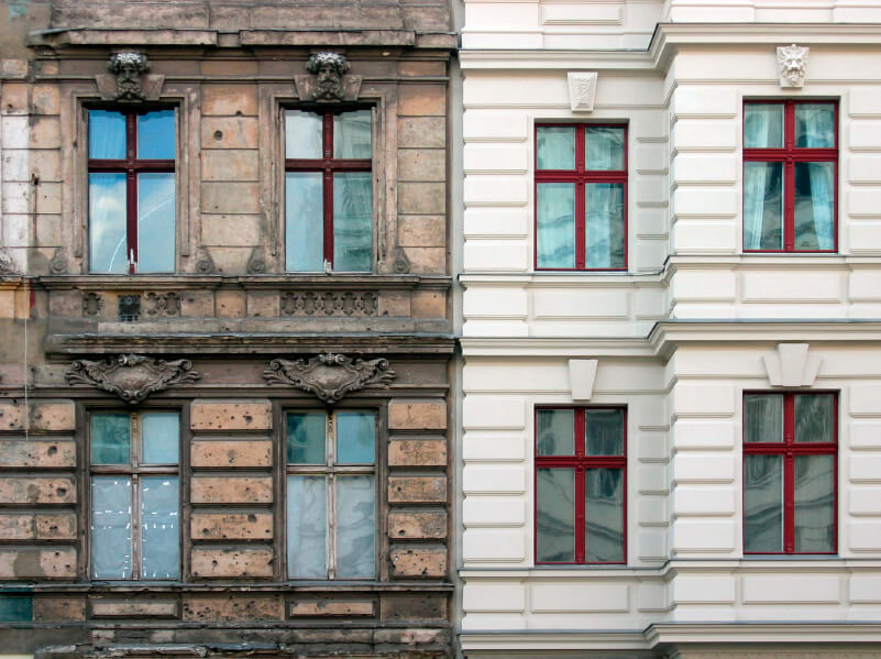 Fassaden zweier Altbau-Mehrfamilienhäuser - links unsaniert, rechts saniert